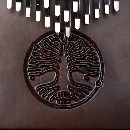 Kalimba/ Hluru ou 'piano a doigt' ! 24 notes, fait en bois de noyer d'Amérque. Vendu avec micro. Décoré d'un Arbre de vie sculpté. Livré avec un sac en tissu et un marteau d'accordage !