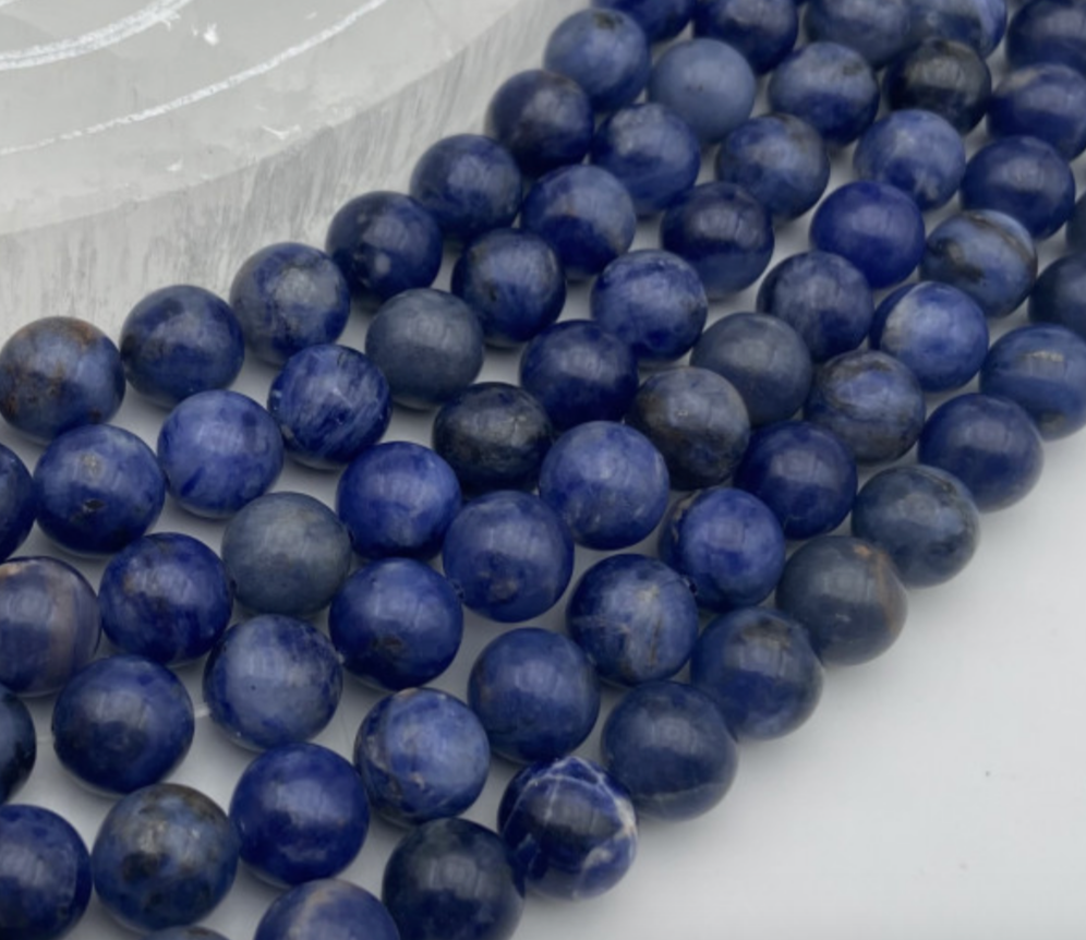 Sodalite qualité Extra, perles rondes de 6 et 8 mm, vendu en : fil de perle 38/39 cm, en bracelet de 17 à 21cm, en collier de 45 ou sautoir de 60cm. Qualité AA à AAA, superbes perles d'un bleu naturel envoûtant !