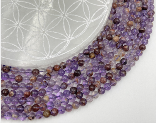 Améthyste 'super seven', perles rondes de 6 ou 8 mm, vendu : en fil de perle 38/39 cm, en bracelet de 17 à 21cm, en collier de 45 ou sautoir de 60cm. Qualité AA à AAA, superbes perles aux reflets violet, parfait !