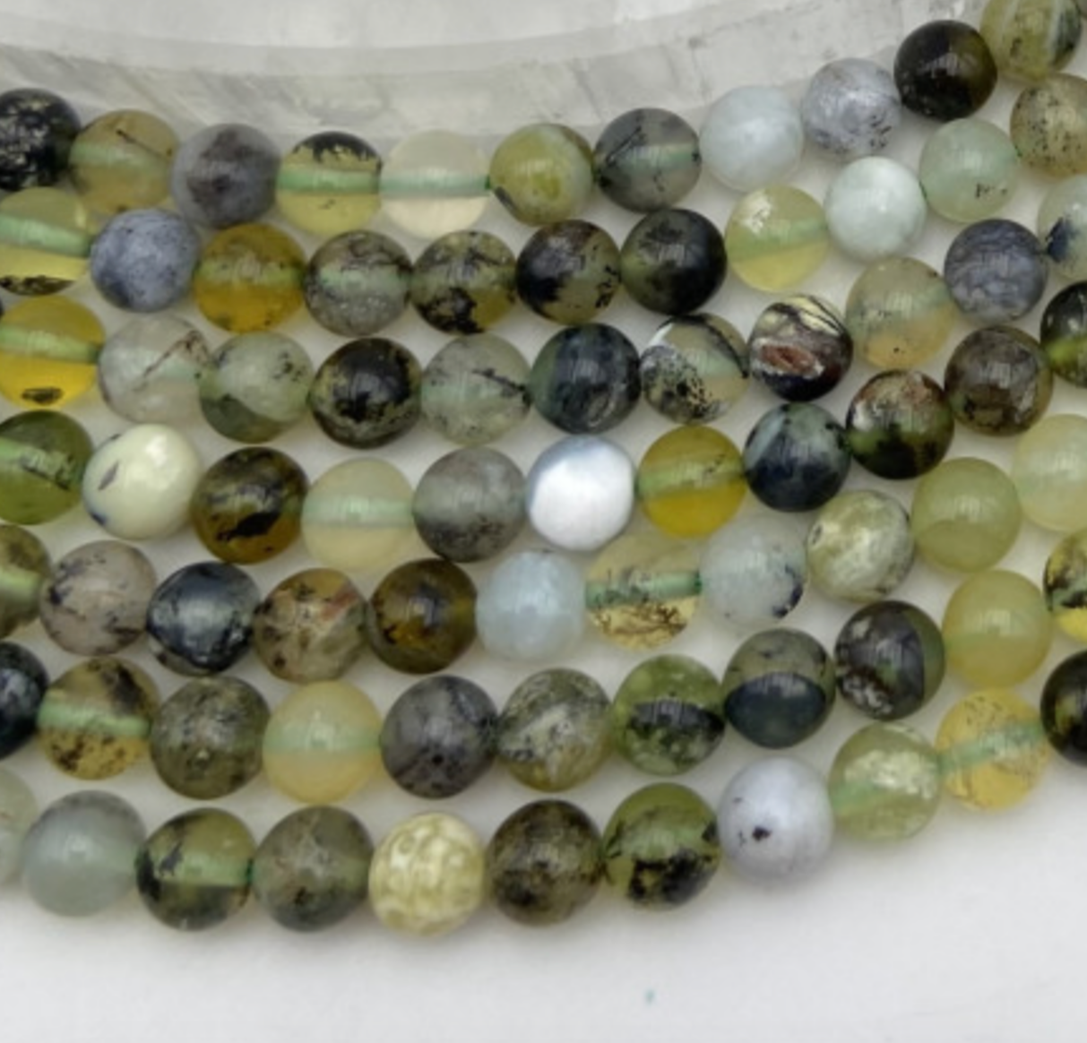 Opale Verte d'Australie, perles rondes de 6 ou 8 mm. Vendu en fil de perle 38/39 cm, en bracelet de 17 à 21cm, en collier de 45 ou sautoir de 60cm. Qualité AA à AAA, superbes perles aux reflets verts cristallins !