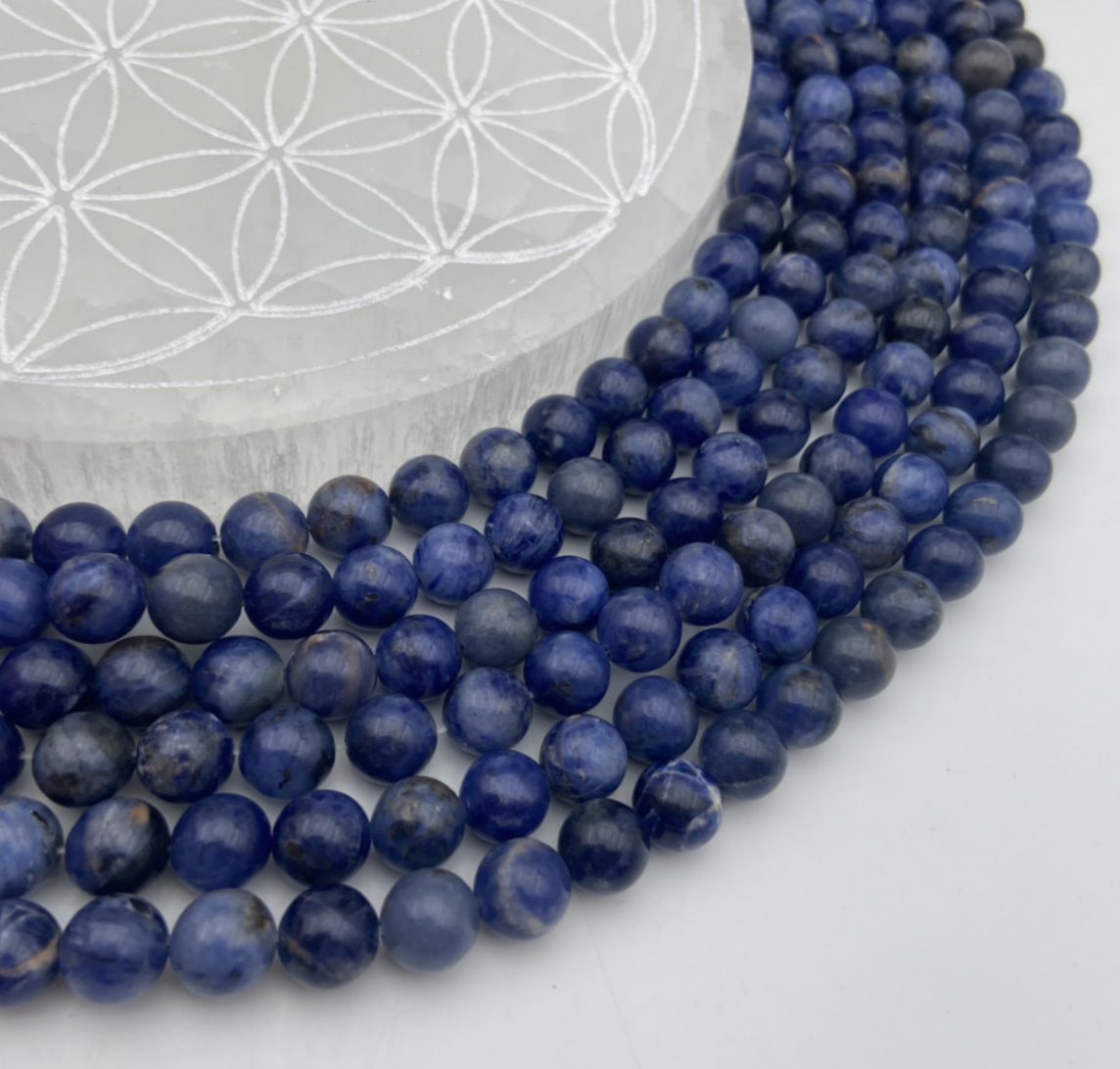 Sodalite qualité Extra, perles rondes de 6 et 8 mm, vendu en : fil de perle 38/39 cm, en bracelet de 17 à 21cm, en collier de 45 ou sautoir de 60cm. Qualité AA à AAA, superbes perles d'un bleu naturel envoûtant !