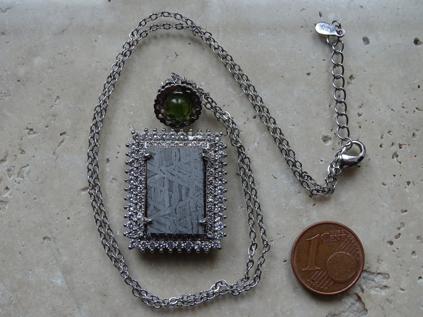 Pendentif 'Deluxe Premium', en météorite 'Muonionalusta' de Suède et perle de Moldavite. Vendu avec chaînette de 45 cm en Argent. Poids 9,5 grammes. Dimensions environ 38x22x0,9 millimètres. Superbe pièce, magnifique !