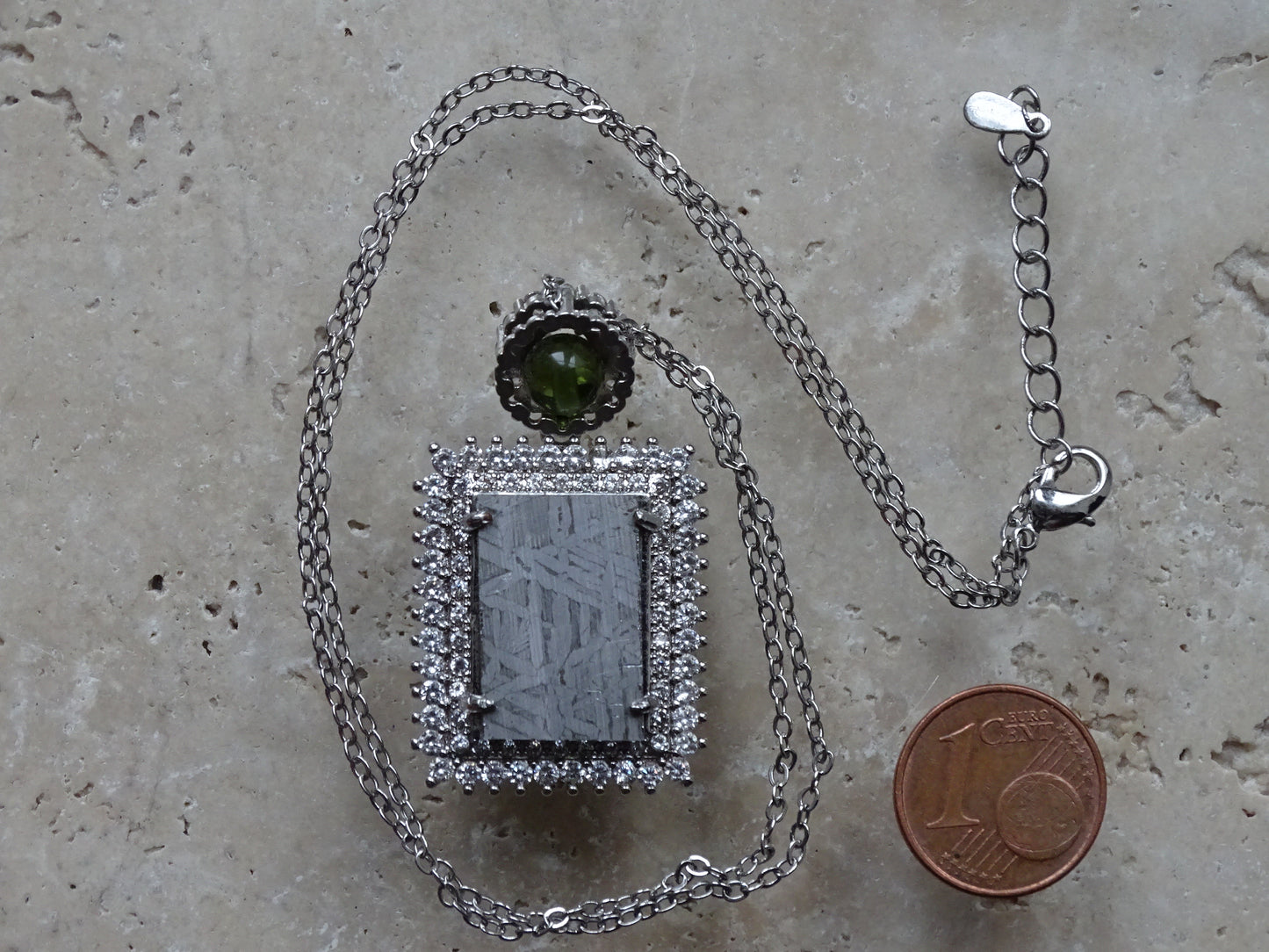 Pendentif 'Deluxe Premium', en météorite 'Muonionalusta' de Suède et perle de Moldavite. Vendu avec chaînette de 45 cm en Argent. Poids 9,5 grammes. Dimensions environ 38x22x0,9 millimètres. Superbe pièce, magnifique !