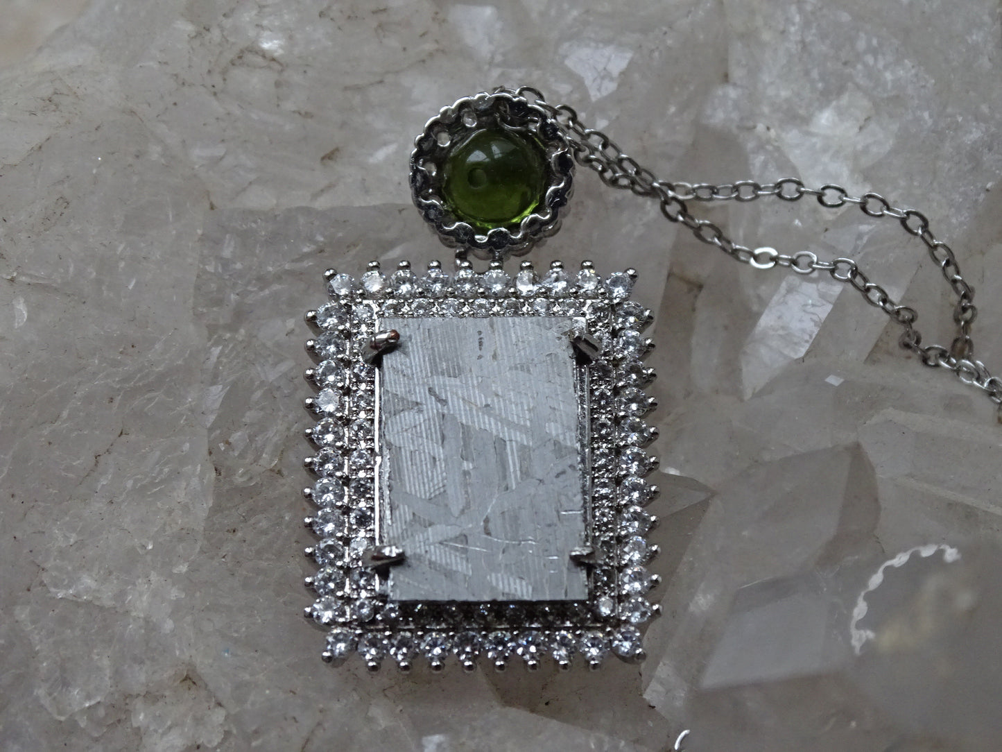 Pendentif 'Deluxe Premium', en météorite 'Muonionalusta' de Suède et perle de Moldavite. Vendu avec chaînette de 45 cm en Argent. Poids 9,5 grammes. Dimensions environ 38x22x0,9 millimètres. Superbe pièce, magnifique !