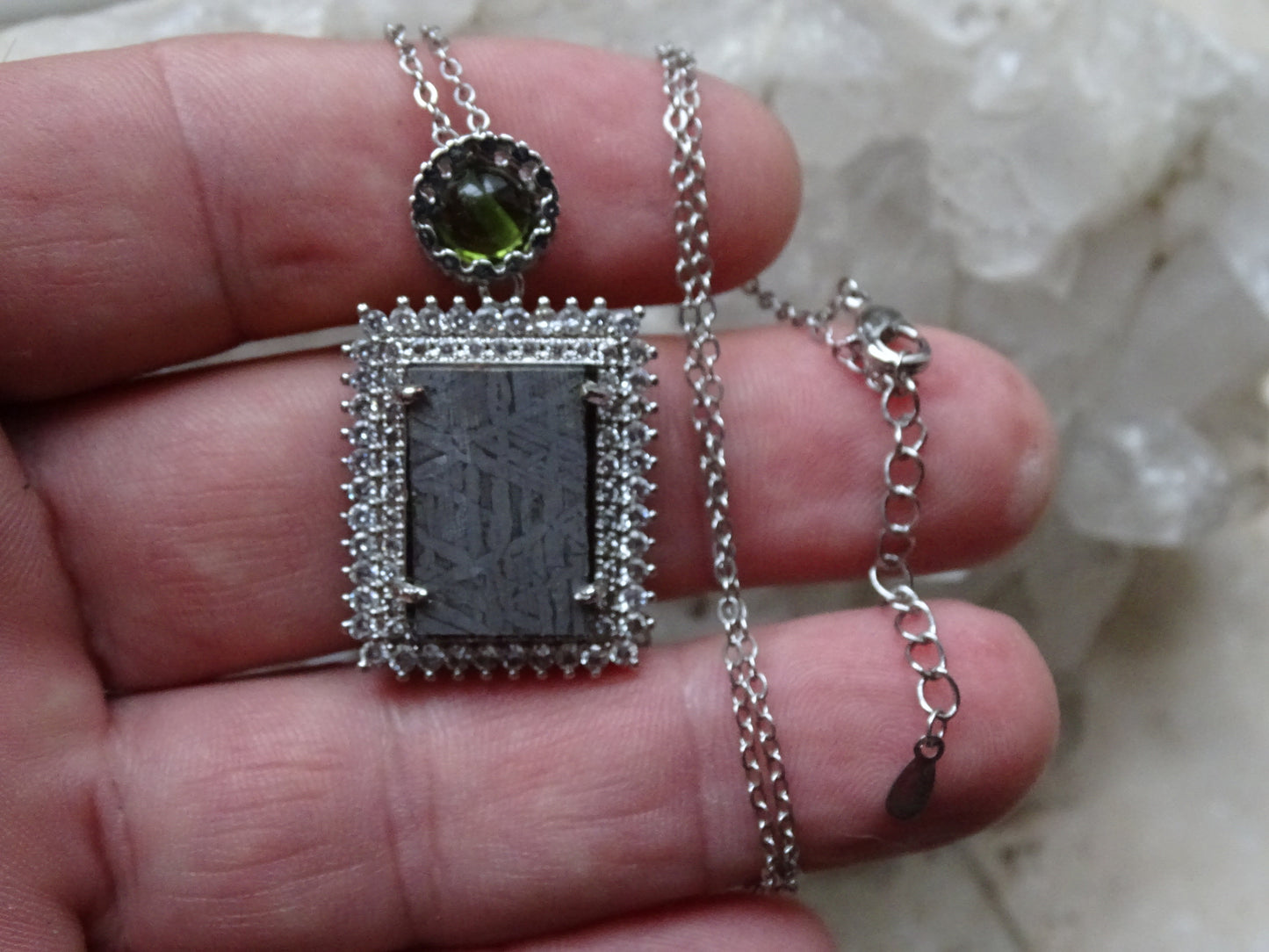 Pendentif 'Deluxe Premium', en météorite 'Muonionalusta' de Suède et perle de Moldavite. Vendu avec chaînette de 45 cm en Argent. Poids 9,5 grammes. Dimensions environ 38x22x0,9 millimètres. Superbe pièce, magnifique !