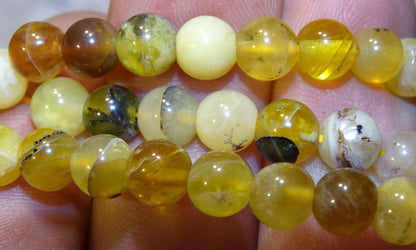 Opale jaune d'Australie, perles rondes de 4, 6 ou 8 mm. Vendu en fil de perle 38/39 cm, en bracelet de 17 à 21cm, en collier de 45 ou sautoir de 60cm. Qualité AA à AAA, superbes perles aux reflets dentriques !