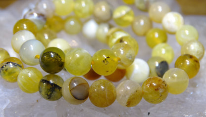 Opale jaune d'Australie, perles rondes de 4, 6 ou 8 mm. Vendu en fil de perle 38/39 cm, en bracelet de 17 à 21cm, en collier de 45 ou sautoir de 60cm. Qualité AA à AAA, superbes perles aux reflets dentriques !