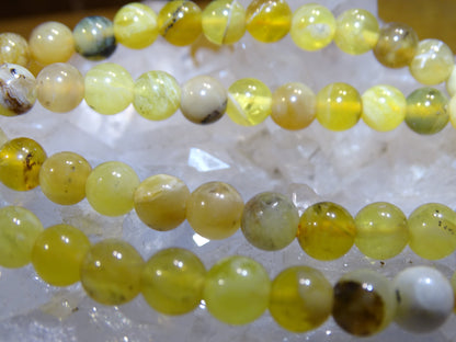 Opale jaune d'Australie, perles rondes de 4, 6 ou 8 mm. Vendu en fil de perle 38/39 cm, en bracelet de 17 à 21cm, en collier de 45 ou sautoir de 60cm. Qualité AA à AAA, superbes perles aux reflets dentriques !