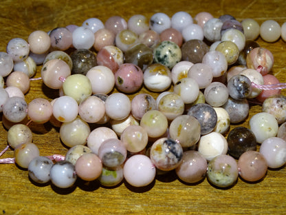 Opale Rose des Andes, perles rondes de 6 ou 8 mm. Vendu en fil de perle 38/39 cm, en bracelet de 17 à 21cm, en collier de 45 ou sautoir de 60cm. Qualité AA à AAA, superbes perles !