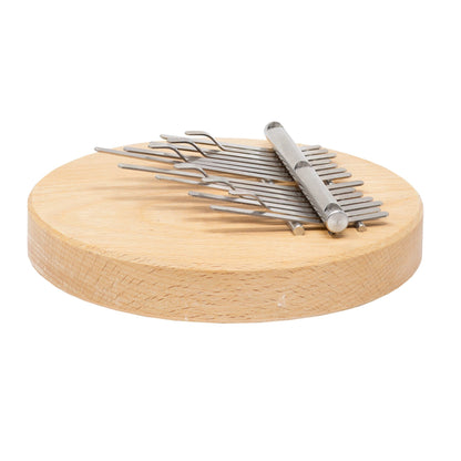 Kalimba 14 notes de Hands on Drum accordé*, avec ou sans aimant intégré (pour fixation sur un cajon ou un tambour). •Ø 14 centimètres, base en bois dur 2 cm de hauteur. Dimensions : 14,00 × 14,00 × 5,00 cm