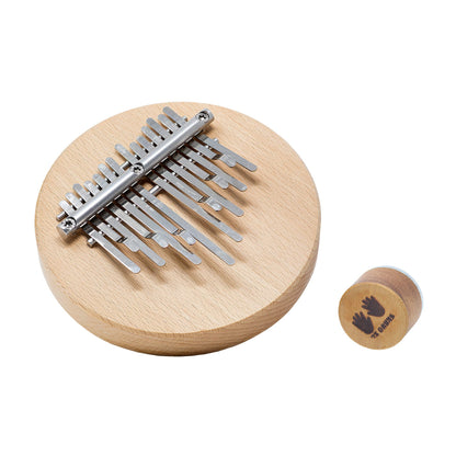 Kalimba 14 notes de Hands on Drum accordé*, avec ou sans aimant intégré (pour fixation sur un cajon ou un tambour). •Ø 14 centimètres, base en bois dur 2 cm de hauteur. Dimensions : 14,00 × 14,00 × 5,00 cm