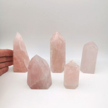 Obélisques en quartz rose du Brésil. 5 tailles au choix de 6 à 11 centimètres. Vente à l'unité ou par 5 (env. 1 kg). Très belle qualité, un effet incroyable, de belles pièces !